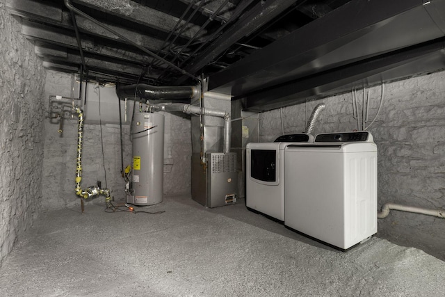 basement featuring washing machine and dryer, heating unit, and gas water heater