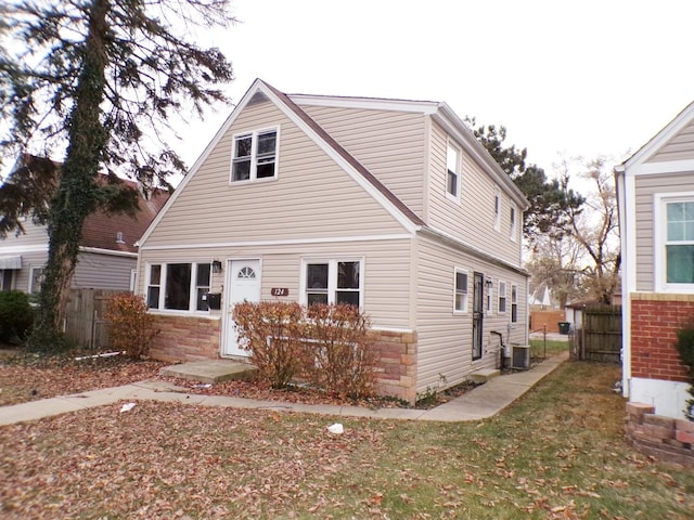 view of front of house with central AC unit and a front lawn