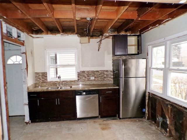 kitchen with dark brown cabinetry, light stone countertops, sink, stainless steel appliances, and decorative backsplash