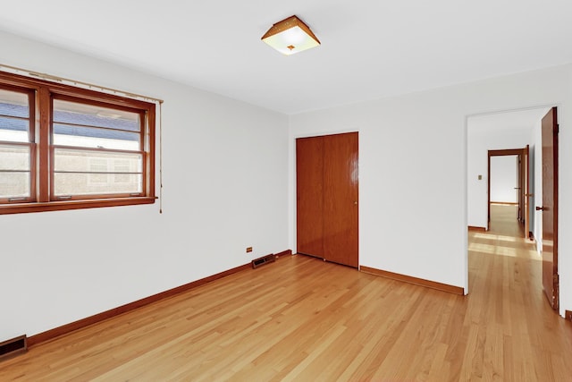 unfurnished bedroom with light hardwood / wood-style flooring and a closet