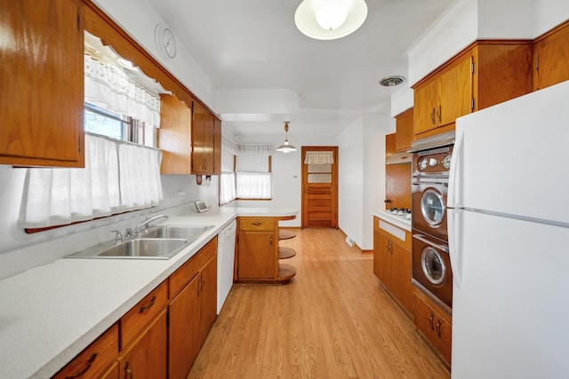 kitchen with sink, pendant lighting, white appliances, and light hardwood / wood-style floors