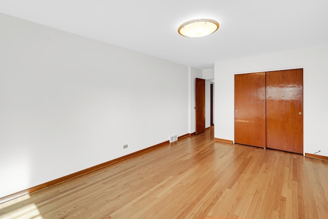 unfurnished bedroom with light hardwood / wood-style floors and a closet