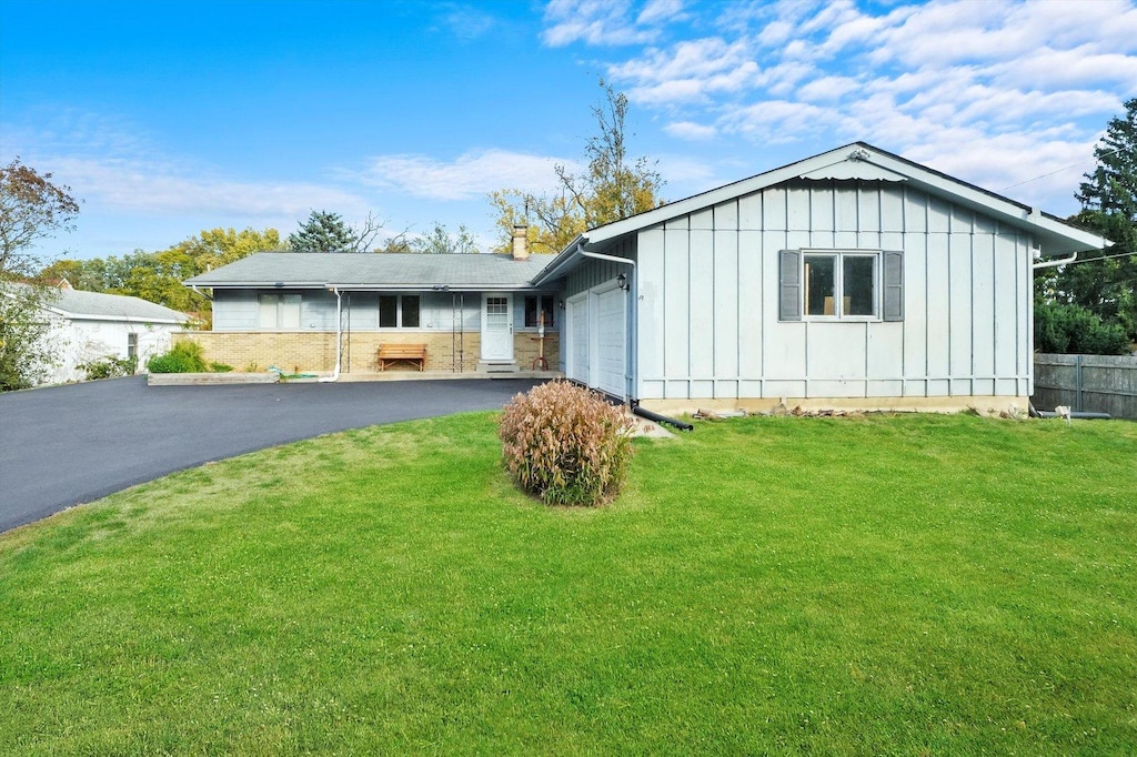 ranch-style house featuring a front lawn and a garage