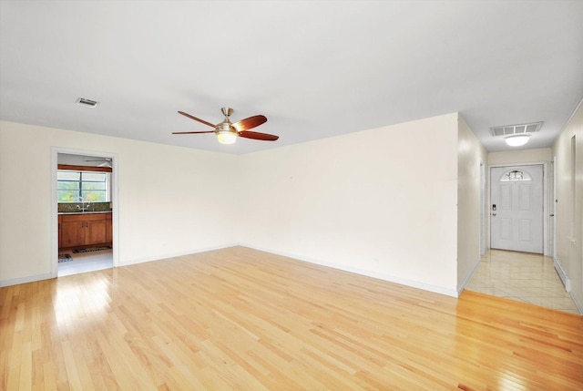 spare room featuring ceiling fan and light wood-type flooring