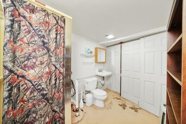 bathroom featuring concrete flooring, toilet, and crown molding