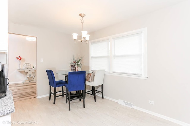 dining area with a notable chandelier and light hardwood / wood-style floors