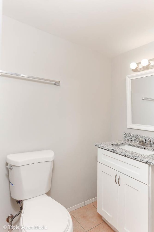 bathroom featuring tile patterned flooring, vanity, and toilet