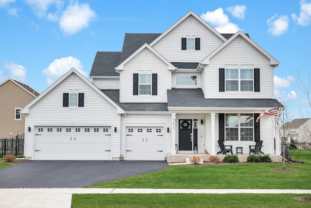 front of property with a porch, a garage, and a front lawn