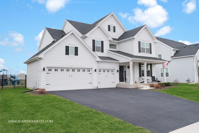 front of property with covered porch, a garage, and a front yard