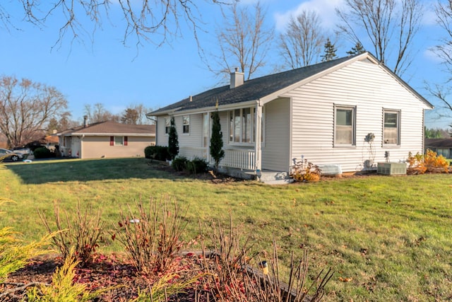 view of side of home featuring a yard and central AC unit