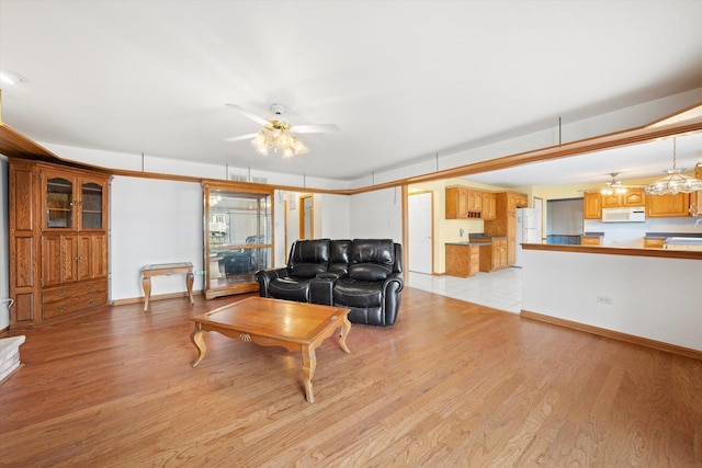 living room featuring ceiling fan and light hardwood / wood-style flooring