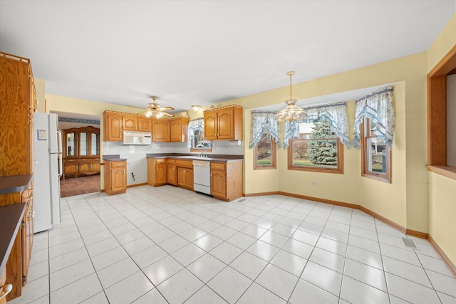 kitchen featuring light tile patterned floors, ceiling fan with notable chandelier, hanging light fixtures, and white appliances