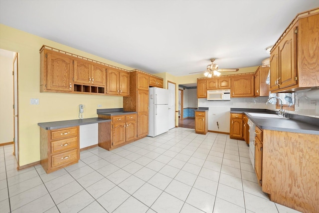 kitchen featuring light tile patterned floors, white appliances, ceiling fan, and sink