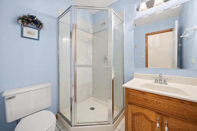 bathroom featuring tile patterned floors, vanity, walk in shower, and toilet