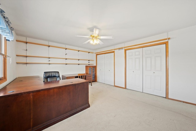 unfurnished office featuring ceiling fan and light colored carpet