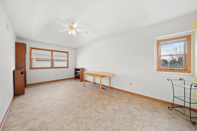 unfurnished room with a raised ceiling and ceiling fan