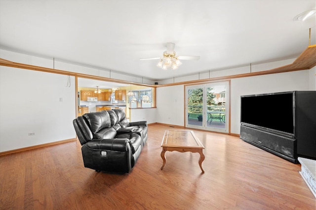 living room with ceiling fan and light hardwood / wood-style flooring