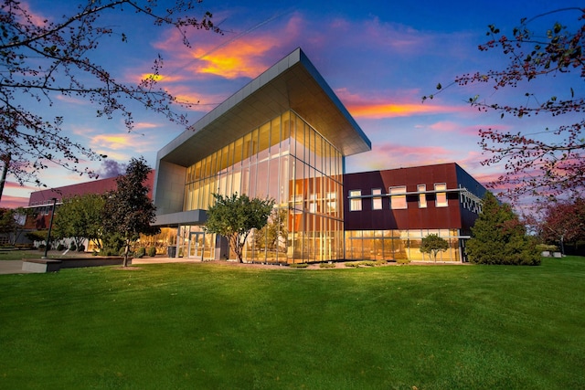 property exterior at dusk featuring a lawn