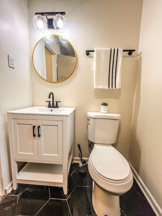 bathroom with toilet, vanity, and tile patterned floors