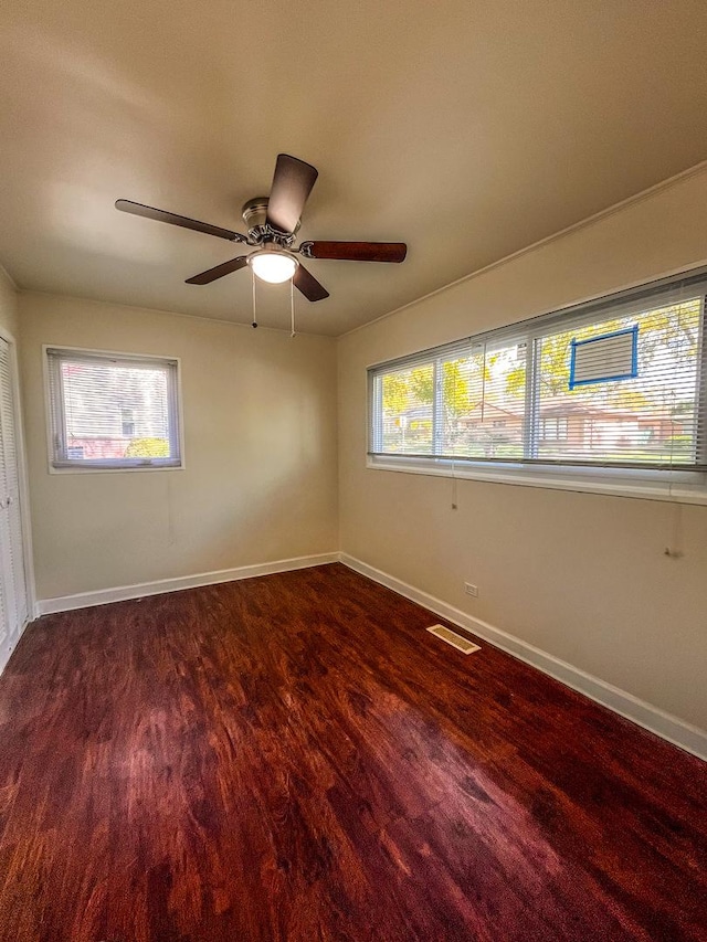 spare room with dark hardwood / wood-style flooring and ceiling fan