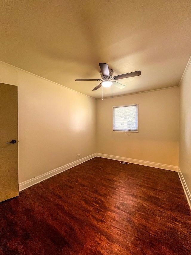 empty room featuring ceiling fan and dark wood-type flooring