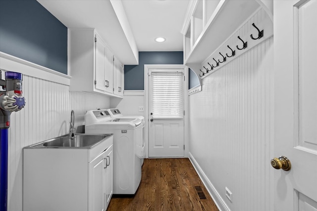 laundry room featuring dark wood-type flooring, sink, cabinets, and washing machine and clothes dryer