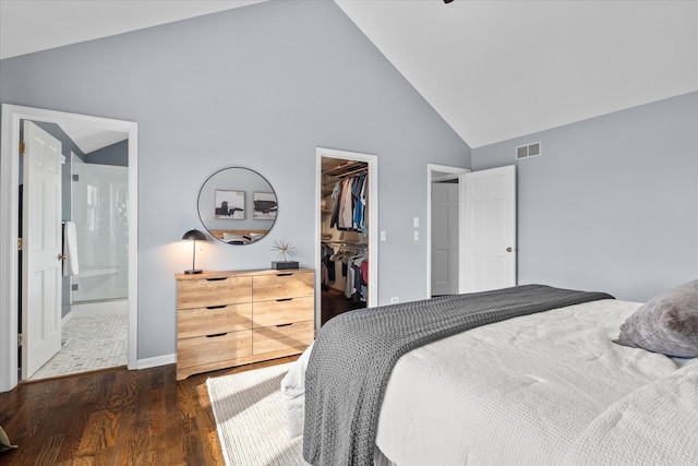 bedroom with dark hardwood / wood-style floors, high vaulted ceiling, a walk in closet, connected bathroom, and a closet