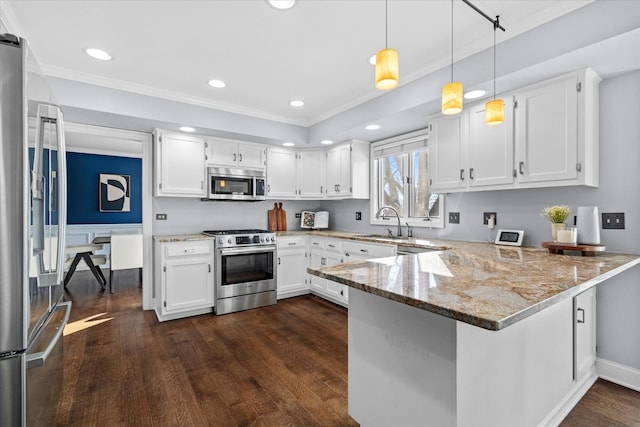 kitchen with decorative light fixtures, white cabinetry, appliances with stainless steel finishes, and kitchen peninsula