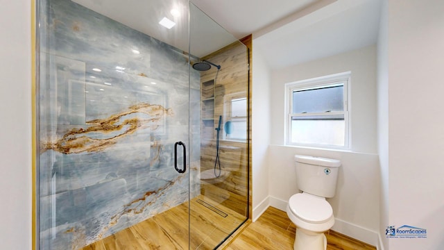 bathroom featuring wood-type flooring, toilet, and a shower with door