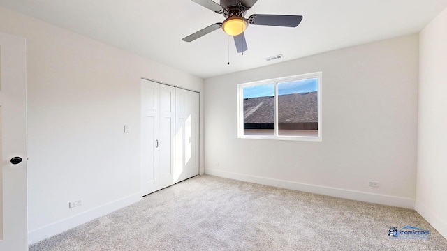 unfurnished bedroom featuring ceiling fan, light carpet, and a closet