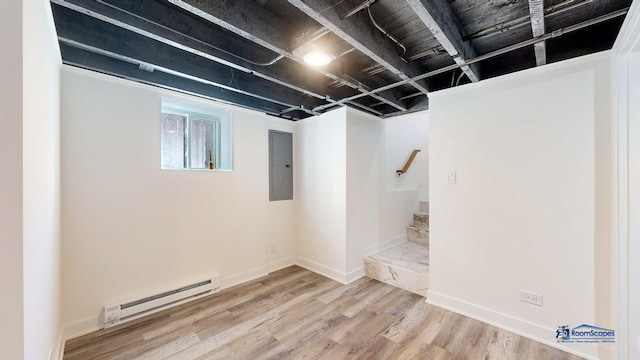 basement featuring electric panel, a baseboard radiator, and hardwood / wood-style flooring