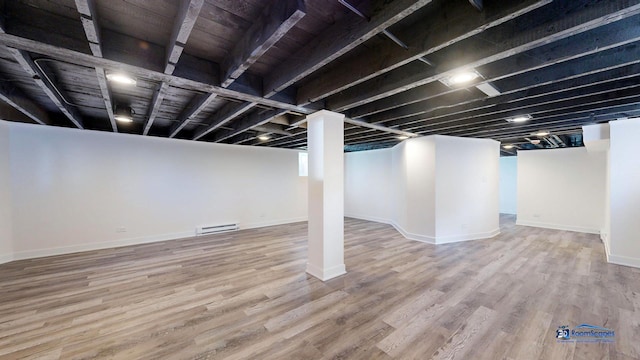 basement with hardwood / wood-style floors and a baseboard heating unit