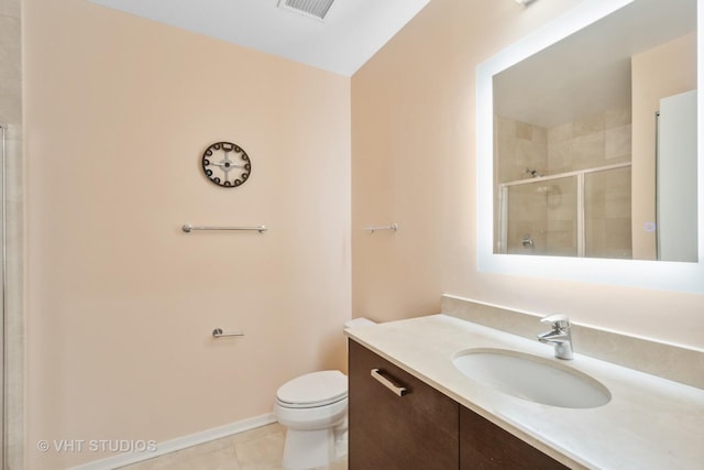 bathroom with tile patterned flooring, vanity, toilet, and walk in shower