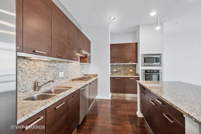 kitchen with backsplash, sink, light stone countertops, dark hardwood / wood-style flooring, and stainless steel appliances