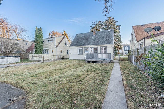 rear view of property with a lawn and a wooden deck