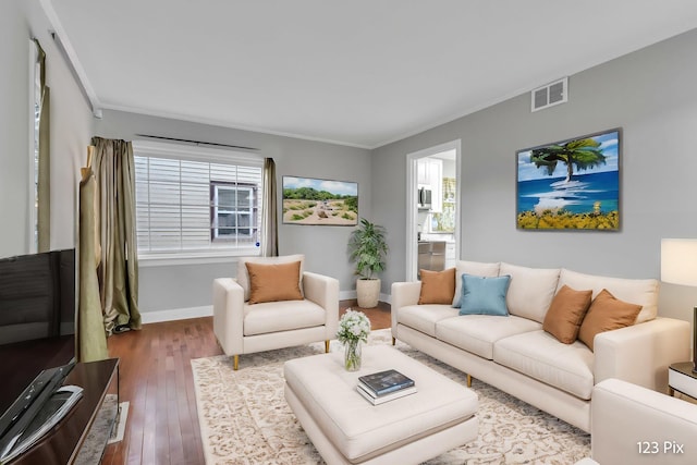 living room with hardwood / wood-style floors and crown molding