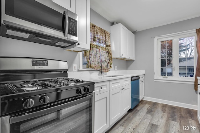 kitchen with white cabinets, dark hardwood / wood-style flooring, sink, and appliances with stainless steel finishes