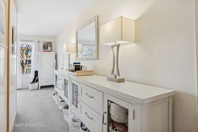 hallway featuring light colored carpet and a wealth of natural light