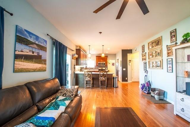 living room with ceiling fan and light wood-type flooring