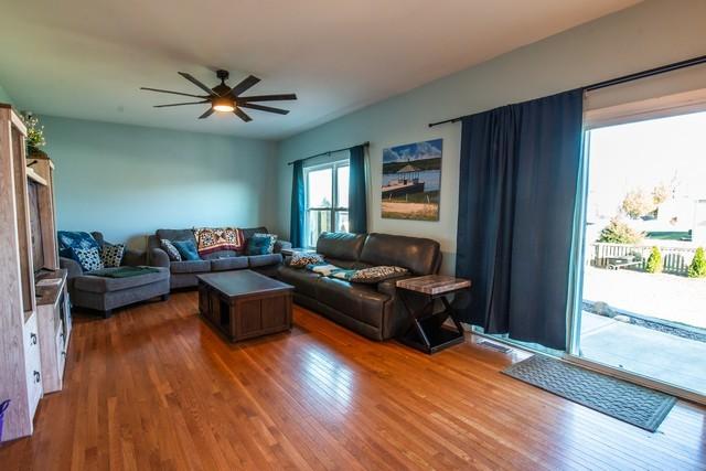 living room featuring ceiling fan and dark wood-type flooring