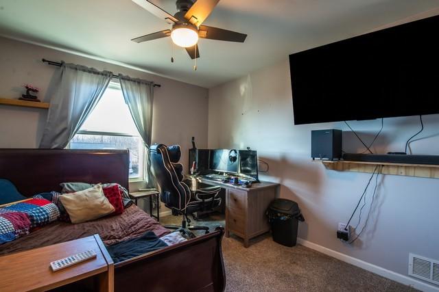 carpeted office featuring ceiling fan