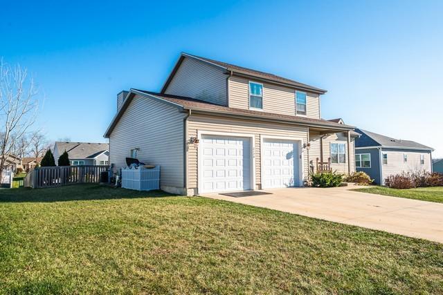 view of front of property with a front yard, a garage, and cooling unit