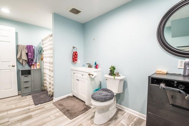 bathroom with vanity, wood-type flooring, and toilet