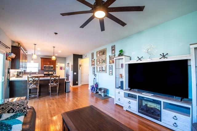 living room featuring ceiling fan and light hardwood / wood-style flooring