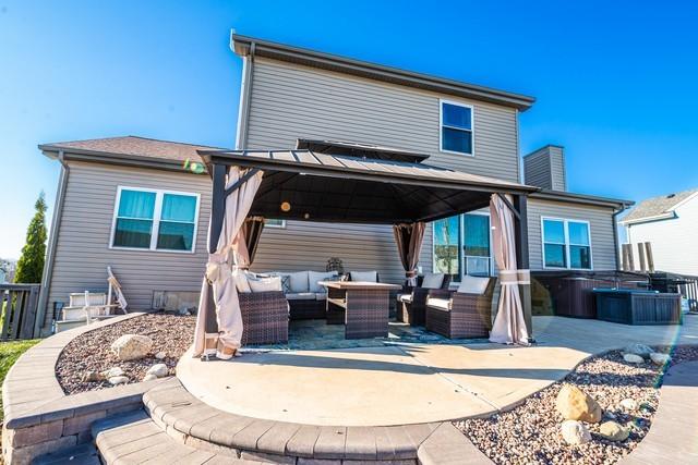 back of house featuring a gazebo, an outdoor hangout area, a patio, and a hot tub