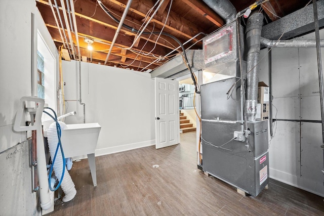 basement with hardwood / wood-style flooring and heating unit