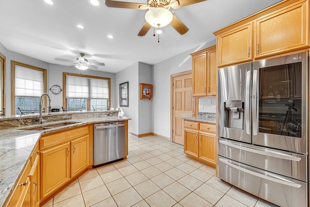 kitchen featuring sink, ceiling fan, light tile patterned floors, appliances with stainless steel finishes, and light stone counters