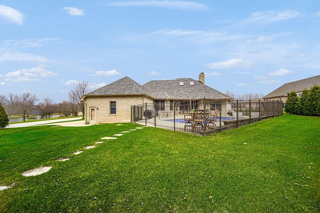 back of house with a fenced in pool, a yard, and a patio