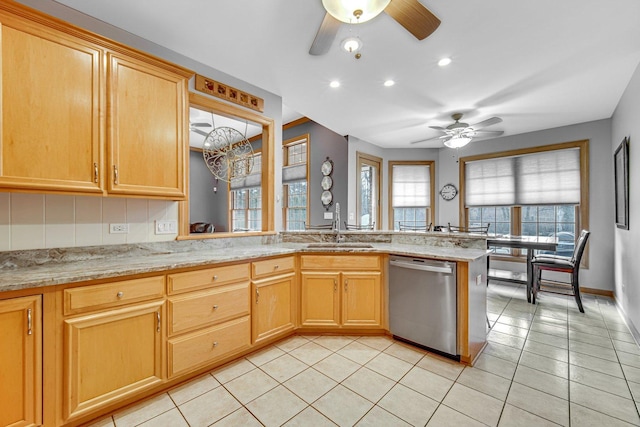 kitchen featuring sink, stainless steel dishwasher, light tile patterned floors, light stone counters, and kitchen peninsula