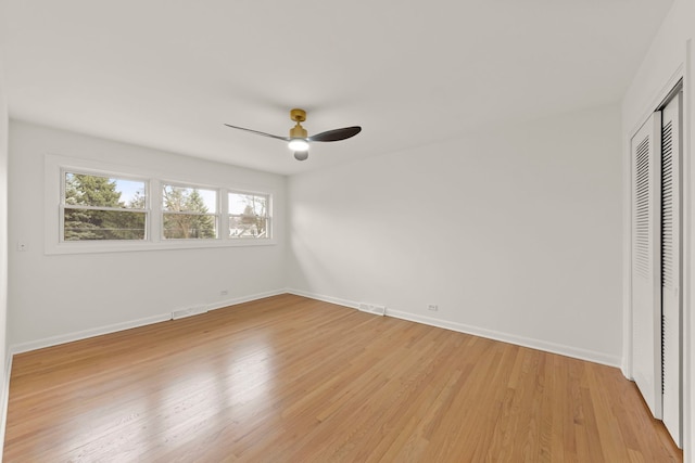 unfurnished bedroom featuring baseboards, visible vents, ceiling fan, light wood-type flooring, and a closet